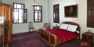 3. Το δωμάτιο φιλοξενίας με την ιδιαίτερα φροντισμένη επίπλωση. / The guest bedroom is adorned with antique furniture, paintings, an elegant sofa and large carpets.